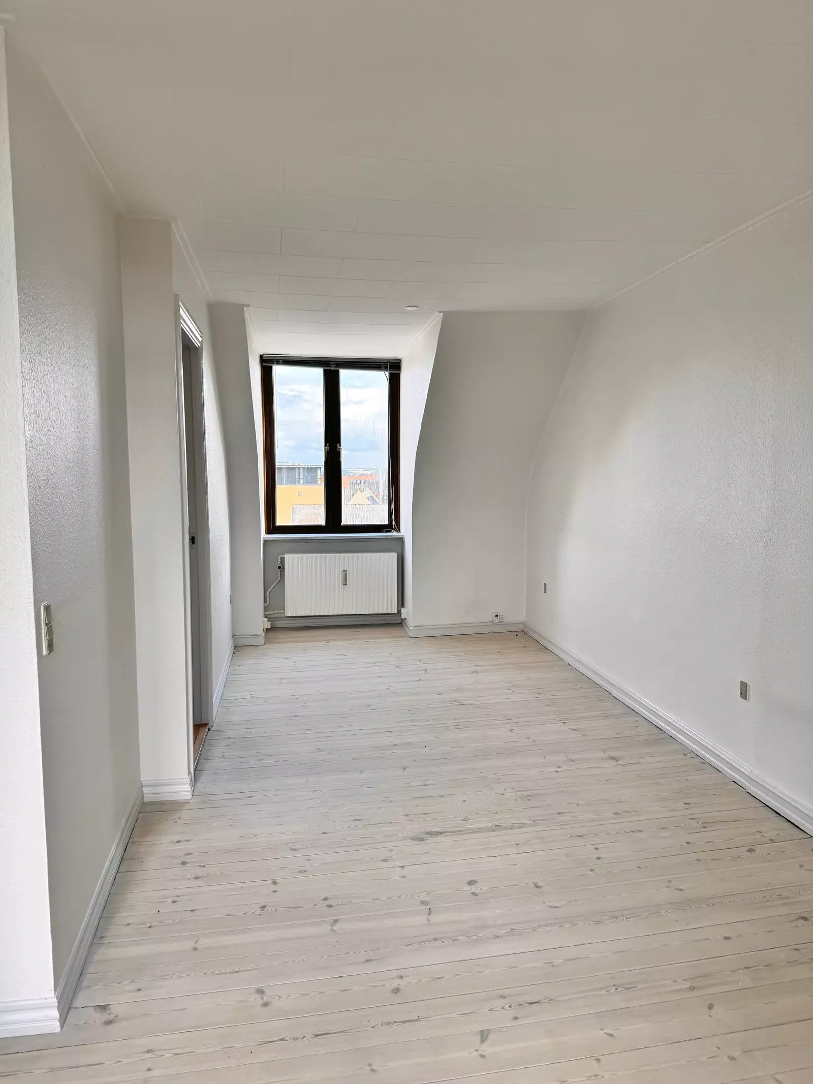 Lys 2-værelses kvistlejlighed på 55 m2 med plankegulve og separat køkken