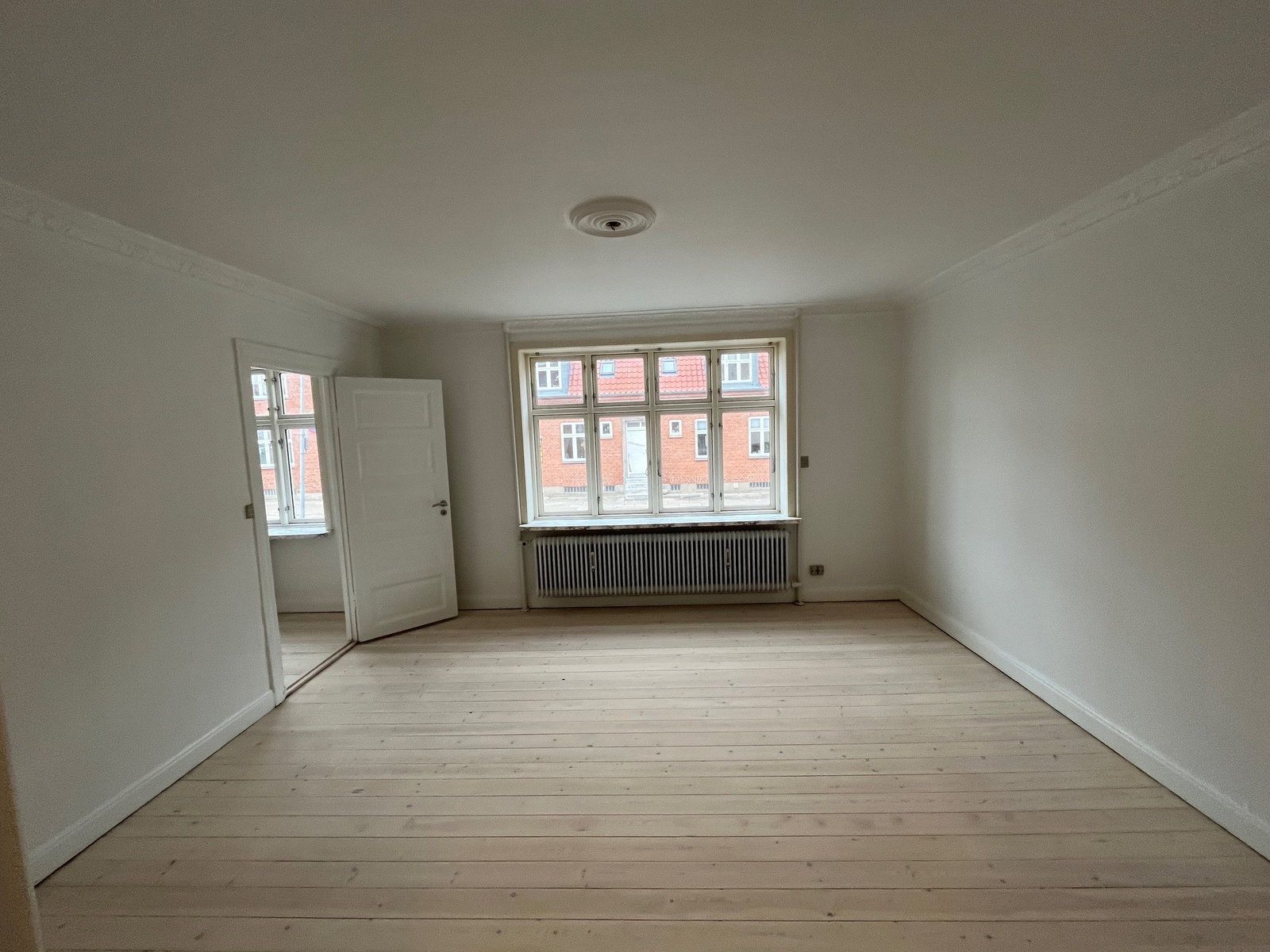 Lys 2-værelses med klassiske detaljer, indbyggede skabe og parkering – 62 m2