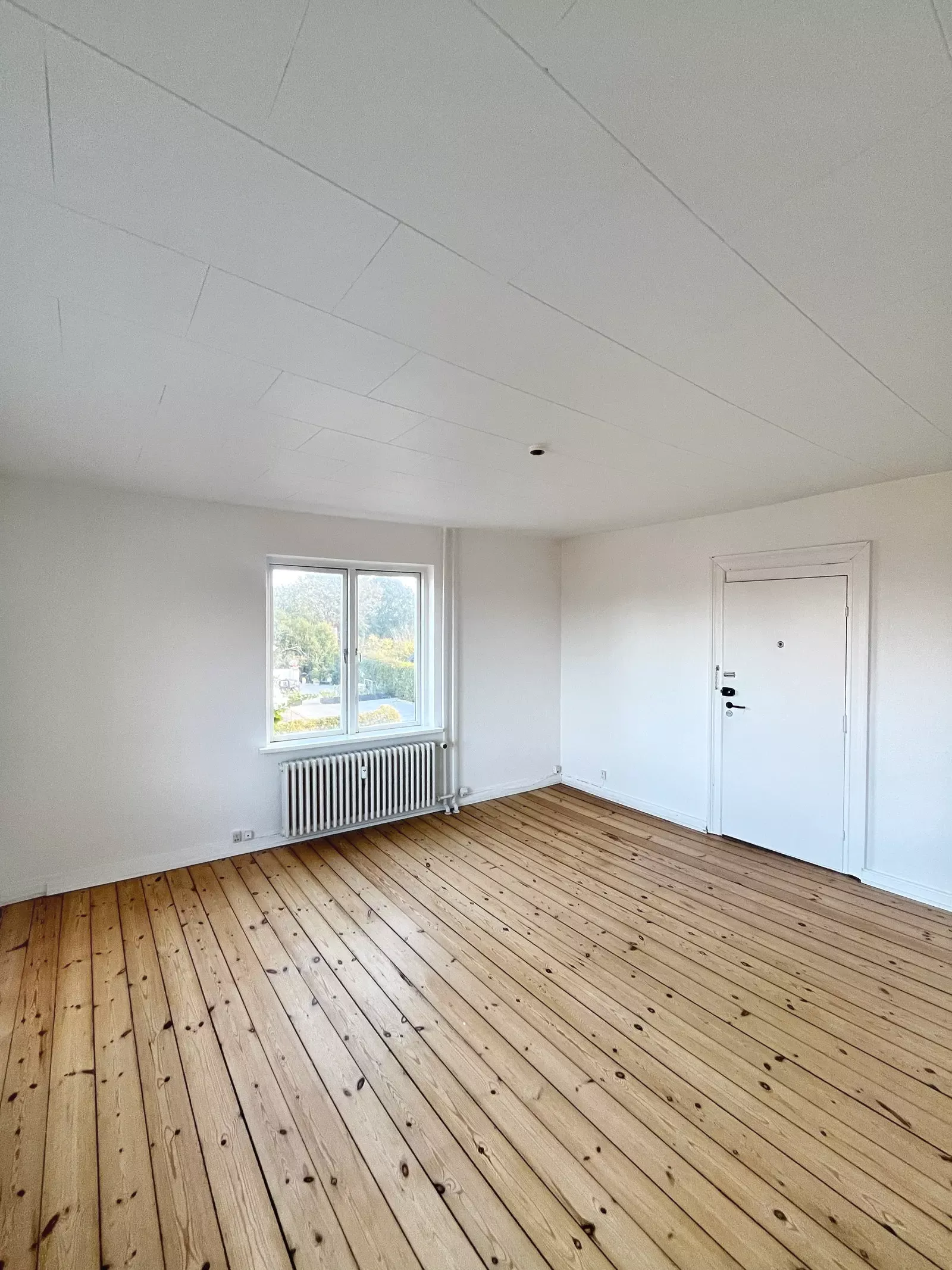 Lys 3-værelses med plankegulve, træloft og klassisk køkken – 85 m2