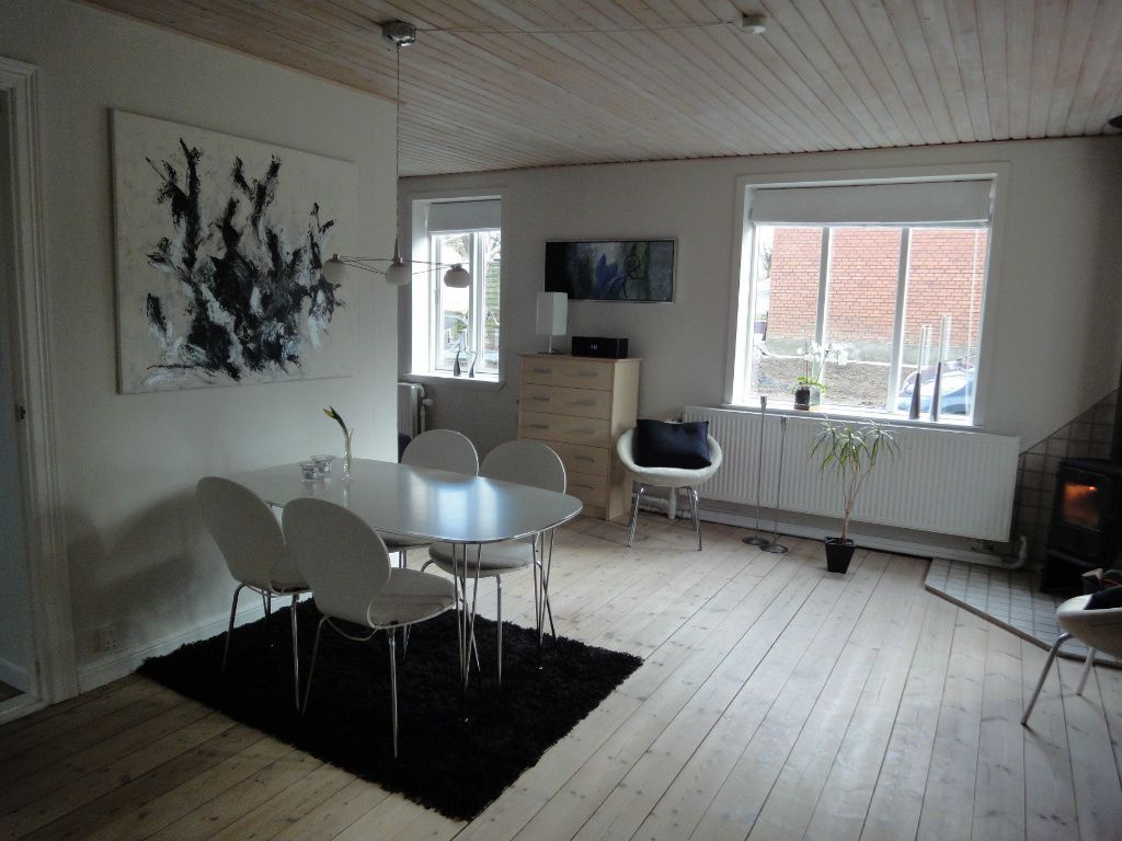 Hus med have, terrasse og garage.