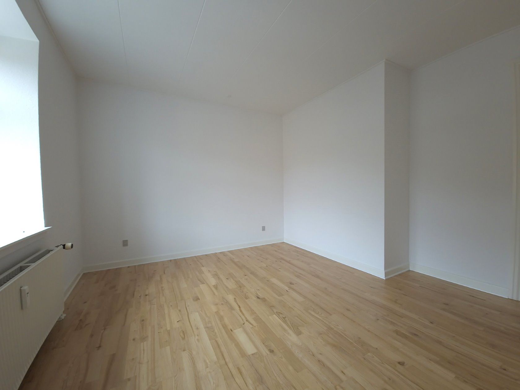 Stor renoveret lejlighed med vaskesøjle og parkering.